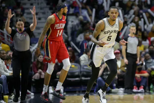 San Antonio Spurs guard Dejounte Murray (5) signals after  making a 3-point basket against New Orleans Pelicans forward Brandon Ingram (14) in the second half of an NBA basketball game in New Orleans, Saturday, Feb. 12, 2022. (AP Photo/Matthew Hinton)
