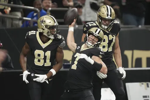 New Orleans Saints tight end Taysom Hill (7) celebrates his touchdown with teammates wide receiver Kevin Austin Jr. (81) and tight end Foster Moreau (87) in the first half of an NFL football game against the Cleveland Browns in New Orleans, Sunday, Nov. 17, 2024. (AP Photo/Gerald Herbert)