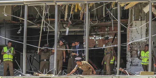 FILE- In this April 21, 2019, file photo, Sri Lankan police officers inspect the site of an explosion at the Shangri-la hotel in Colombo, Sri Lanka. Sri Lanka’s government will appoint a parliamentary committee to investigate allegations made in a British television report that Sri Lankan intelligence had complicity in the 2019 Easter Sunday bombings that killed 269 people. (AP Photo/Chamila Karunarathne, file)
