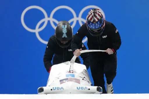 Kaillie Humphries of the United States starts a run during a 2-woman bobsled training at the 2022 Winter Olympics, Wednesday, Feb. 16, 2022, in the Yanqing district of Beijing. (AP Photo/Mark Schiefelbein)