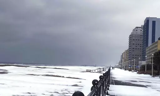 Snow covers the Virginia Beach oceanfront, Saturday, Jan. 22, 2022 in Virginia Beach, Va.  A layer of ice and a blanket of snow has covered coastal areas stretching from South Carolina to Virginia. The winter weather system that entered the region on Friday brought colder temperatures and precipitation not often seen in the region. (Stacy Parker/The Virginian-Pilot via AP)