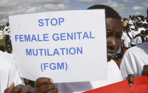 A Masai girl holds a protest sign during the anti-Female Genital Mutilation (FGM) run in Kilgoris, Kenya, on April 21, 2007. Lawmakers in the West African nation of Gambia on Monday July 15, 2024 rejected a bill that would have overturned a ban on female genital cutting. The attempt to become the first country in the world to reverse such a ban had been closely followed by activists abroad. (AP Photo/Sayyid Azim, File)