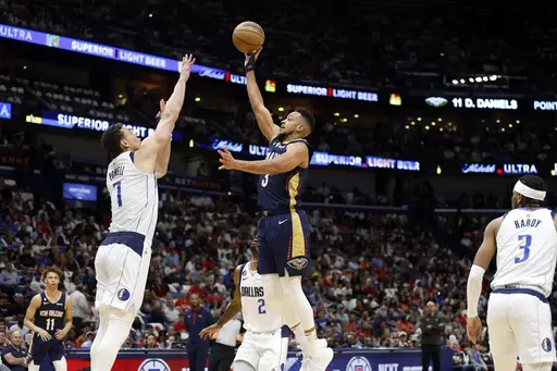 New Orleans Pelicans guard CJ McCollum (3) shoots the ball over Dallas Mavericks center Dwight Powell (7) in the first half of an NBA basketball game in New Orleans, Wednesday, March 8, 2023. (AP Photo/Tyler Kaufman)