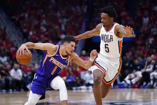 Phoenix Suns guard Devin Booker (1) drives to the basket against New Orleans Pelicans forward Herbert Jones (5) in the second half of Game 6 of an NBA basketball first-round playoff series, Thursday, April 28, 2022 in New Orleans. The Suns won 115-109, to win the series 4-2 and advance to the second-round. (AP Photo/Gerald Herbert)