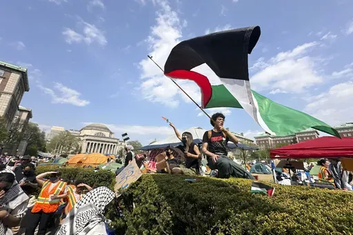 A demonstrator waves a flag on the Columbia University campus at a pro-Palestinian protest encampment, in New York, April 29, 2024. (AP Photo/Ted Shaffrey, File)
