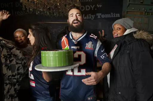 In a photo provided by Marisha Camp, Meir Kay, founder of Super Soul Party, holds a cake at a Super Bowl party organized by his nonprofit organization for homeless people, Feb. 3, 2019, in New York. Super Soul Party, a nonprofit started by filmmaker and social media influencer Meir Kay, will have Super Bowl parties in 35 cities when the Cincinnati Bengals and Los Angeles Rams meet Feb. 13. (Marisha Camp via AP)