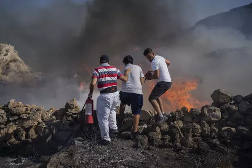 Local residents try to extinguish a fire, near the seaside resort of Lindos, on the Aegean Sea island of Rhodes, southeastern Greece, on July 24, 2023. Greece’s resort island of Rhodes is nursing its wounds after 11 days of devastating wildfires. (AP Photo/Petros Giannakouris, File)