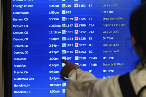 A traveler checks the departures flight board at the United Airlines terminal at Los Angeles International airport, on Wednesday, June 28, 2023, in Los Angeles. (AP Photo/Damian Dovarganes)