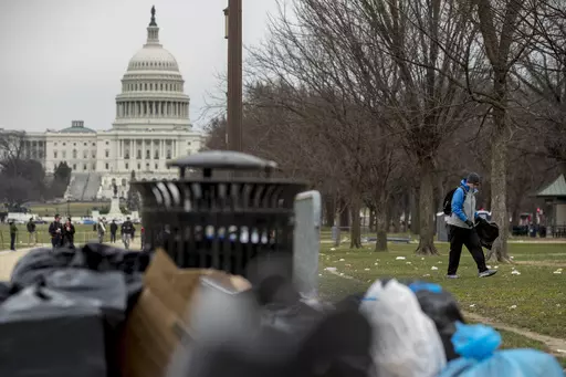 The Capitol building is visible as a man who declined to give his name, right, picks up garbage during a partial government shutdown on the National Mall in Washington, Dec. 25, 2018. All the hand-wringing over a potential government default if Congress doesn’t increase the national debt limit has conjured up images of past government shutdowns when TSA agents worked without pay and litter piled up in untended national parks. In fact, there’s a big difference between a government default and