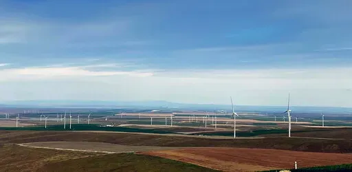 In this photo provided by Portland General Electric, windmills are seen at a renewable energy facility in Lexington, Ore., May 24, 2022, that combines solar power, wind power and massive batteries to store the energy generated there. The Wheatridge Renewable Energy Facilities was commissioned Wednesday, Sept. 28, 2022, and is the first utility-scale plant of its kind in North America. Clean energy experts say the project, which can power 100,000 homes, addresses some key challenges facing the in