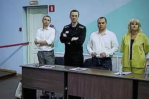 Russian opposition leader Alexei Navalny, 2nd left, is seen on a TV screen standing among his lawyers, as he appears in a video link provided by the Russian Federal Penitentiary Service, during a hearing in the colony, in Melekhovo, Vladimir region, about 260 kilometers (163 miles) northeast of Moscow, Russia, on Friday, Aug. 4, 2023. Navalny on Friday was convicted on extremism charges and sentenced to 19 years in prisons, in the harshest ruling against the imprisoned Kremlin critic to date. (A