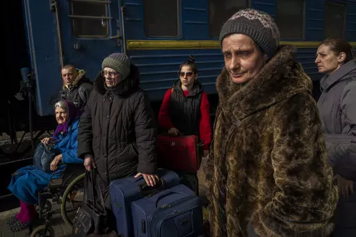 Ukrainians escaping from the besieged city of Mariupol along with other passengers from Zaporizhzhia arrive at Lviv, western Ukraine, on Sunday, March 20, 2022. (AP Photo/Bernat Armangue)