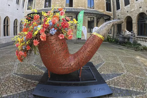 A giant pipe with flowers. in the interior yard of City Hall, Brussels, Belgium, Friday Aug. 11, 2023. The floral art was inspired by Belgian surrealist artist Rene Magritte’s “This is not a pipe”. Belgium has a century-old fling with surrealism and is always proud to flaunt it. This year they're combining it with an annual flower show in Brussels. (AP Photo/Mark Carlson)