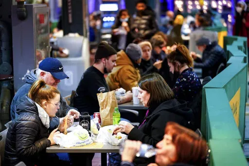 Customers eat at the Reading Terminal Market in Philadelphia, Wednesday, Feb. 16, 2022.  Philadelphia city officials lifted the city's vaccine mandate for indoor dining and other establishments that serve food and drinks, but an indoor mask mandate remains in place. Philadelphia Public Health officials announced that the vaccine mandate was lifted immediately Wednesday. (AP Photo/Matt Rourke)