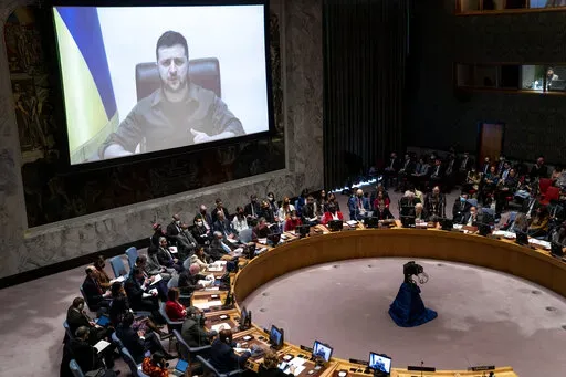 Ukrainian President Volodymyr Zelenskyy speaks via remote feed during a meeting of the UN Security Council, Tuesday, April 5, 2022, at United Nations headquarters.  Zelenskyy will address the U.N. Security Council for the first time Tuesday at a meeting that is certain to focus on what appear to be widespread deliberate killings of civilians by Russian troops. (AP Photo/John Minchillo)