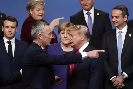 NATO Secretary-General Jens Stoltenberg, front center left, speaks with U.S. President Donald Trump, front center right, after a group photo at a NATO leaders meeting at The Grove hotel and resort in Watford, Hertfordshire, England, Dec. 4, 2019. As Trump becomes the first former president to face federal charges that could put him in jail, many Europeans are watching the case closely. But hardly a single world leader has said a word recently about the man leading the race for the Republican par