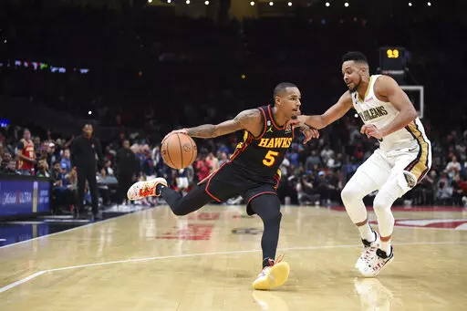 Atlanta Hawks' Dejounte Murray, left, drives past New Orleans Pelicans' CJ McCollum during the second half of an NBA basketball game Saturday, Nov. 5, 2022, in Atlanta. (AP Photo/Hakim Wright Sr.)