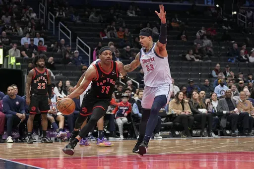 Toronto Raptors forward Bruce Brown (11) dribbles the ball to the hoop against Washington Wizards forward Kyle Kuzma (33) during the first half of an NBA basketball game Wednesday, Jan. 29, 2025, in Washington. (AP Photo/Jess Rapfogel)