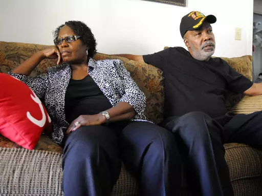 Sarah Collins Rudolph and her husband, George Rudolph, talk in their home on Nov. 16, 2016, in Birmingham, Ala. Rudolph lost an eye and still has slivers of glass inside her body from the racist bombing that killed her sister and three other Black girls inside a church 59 years ago Thursday. She's still waiting on the state to compensate her for those injuries. (AP Photo/Jay Reeves, File)