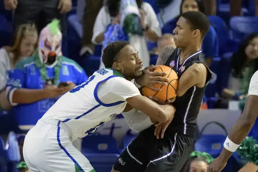 Texas A&M Corpus Christi guard Hansel Enmanuel (24) grabs a rebound from Texas A&M Corpus Christi forward Isaac Mushila (10) during the first half an NCAA college basketball game in the finals of the Southland Conference men's tournament in Lake Charles, La., Wednesday, March 8, 2023. (AP Photo/Matthew Hinton)
