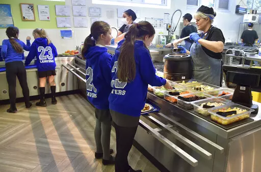 A general view of pupils during lunch hour at Hillstone Primary School, in Birmingham, England, Wednesday, Nov. 30, 2022. For some children in low-income areas in England, a school lunch may be the only nutritious hot meal they get in a day. School lunches are given for free to all younger children in England and to some of the poorest families. But the Food Foundation charity estimates that there are 800,000 children in England living in poverty who are not eligible for the free meals. (AP Phot