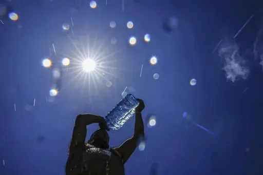 A man pours cold water onto his head to cool off on a sweltering hot day in the Mediterranean Sea in Beirut, Lebanon, July 16, 2023. As temperatures and humidity soar outside, what's happening inside the human body can become a life-or-death battle decided by just a few degrees. (AP Photo/Hassan Ammar, File)