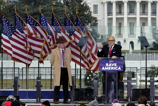 Chapman University law professor John Eastman stands at left as former New York Mayor Rudolph Giuliani speaks in Washington at a rally in support of President Donald Trump, called the "Save America Rally" on Jan. 6, 2021. The latest federal indictment against Donald Trump vividly illustrates the extent to which the former president's final weeks in office were consumed by a struggle over the law, with two determined groups of attorneys fighting it out as the future of American democracy hung in 