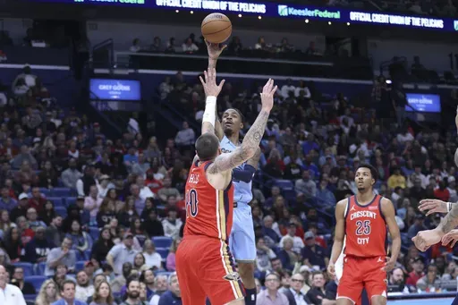 Memphis Grizzlies guard Ja Morant, center top, shoots a floater over New Orleans Pelicans center Daniel Theis (10) in the first half of an NBA basketball game in New Orleans, Friday, Dec. 27, 2024. (AP Photo/Peter Forest)