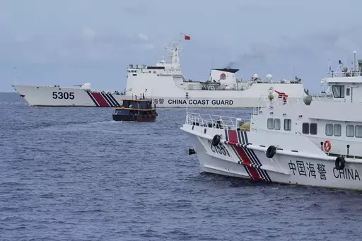 A Philippine supply boat, center, maneuvers around Chinese coast guard ships as they tried to block its way near Second Thomas Shoal, locally known as Ayungin Shoal, at the disputed South China Sea on Tuesday, Aug. 22, 2023. As a US Navy plane circled overhead, two Philippine navy-manned boats manage to breach through a Chinese coast guard blockade in a dangerous confrontation in the disputed South China Sea and succeeded in delivering food and other supplies to Filipino forces guarding a contes