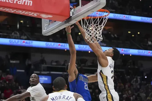 New Orleans Pelicans guard Trey Murphy III blocks a shot by Dallas Mavericks guard Spencer Dinwiddie in the final four seconds of the second half of an NBA basketball game in New Orleans, Wednesday, Jan. 15, 2025. The Pelicans won 119-116. (AP Photo/Gerald Herbert)