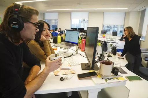John D'Amico, deputy executive editor for The News Movement (TNM), a social media news operation re-imagined for Gen-Z consumers, left, reviews video with reporter Kimberly Avalos, Wednesday, March 1, 2023, in New York. TNM uses a staff of reporters with an average age of 25 to make tailored news content for sites like TikTok, Instagram, YouTube and Twitter. (AP Photo/Bebeto Matthews)