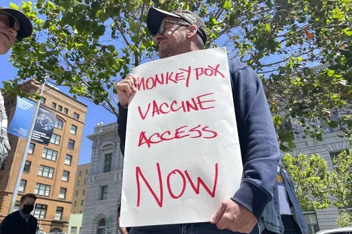 A man holds a sign urging increased access to the monkeypox vaccine during a protest in San Francisco on July 18, 2022. With monkeypox cases subsiding in Europe and parts of North America, many scientists say now is the time to prioritize stopping the virus in Africa. (AP Photo/Haven Daley, File)