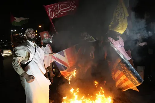 Iranian demonstrators burn representations of British and U.S. flags during a protest against the U.S. and British military strike against Iranian-backed Houthis in Yemen, in front of the British Embassy in Tehran, Iran, Jan. 12, 2024. The next president could be "forced to either sell Iran to Trump or spark a dangerous tension in the country” if economic problems aren't solved, warned Mohammad Bagher Qalibaf, Iran’s parliament speaker and a candidate in the election to be held on Friday, Ju