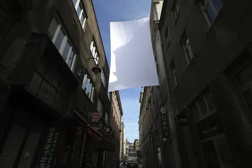 A cloth representing sniper protection screen is displayed in downtown in Sarajevo, Bosnia, Monday, April 4, 2022. Sarajevo is paying a subdued tribute to the resilience of its citizens who survived the longest military siege in modern history, and commemorating thousands of others who did not. Many of the survivors said they found the 30th anniversary of the start of the siege of the Bosnian capital particularly hard because they are marking it against the backdrop of what they describe as simi