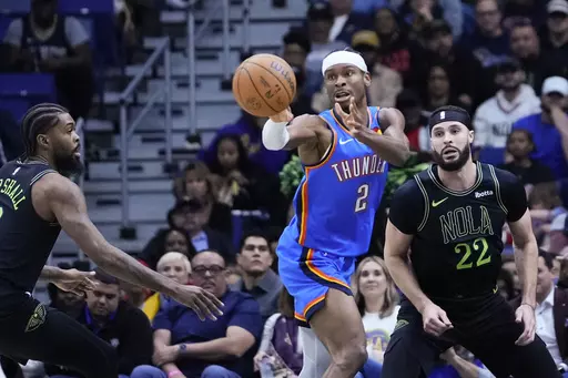 Oklahoma City Thunder guard Shai Gilgeous-Alexander (2) passes between Oklahoma City Thunder guard Cason Wallace (22) and forward Naji Marshall (8) in the first half of an NBA basketball game in New Orleans, Friday, Jan. 26, 2024. (AP Photo/Gerald Herbert)