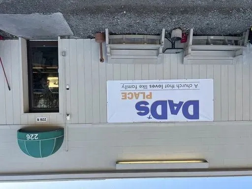 A banner announcing Dad's Place is displayed on the church's back entrance, in Bryan, Ohio, Dec. 17, 2024. (AP Photo/Patrick Aftoora-Orsagos, File)