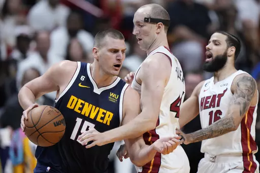 Denver Nuggets center Nikola Jokic (15) dribbles around Miami Heat center Cody Zeller (44) during the first half of Game 4 of the basketball NBA Finals, Friday, June 9, 2023, in Miami. (AP Photo/Wilfredo Lee)