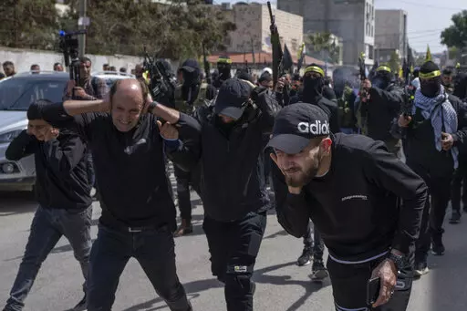 Palestinian gunmen shoot in the air during the funerals for Sanad Abu Atiyeh, 17 and Yazid al-Saadi, 23, in the West Bank refugee camp of Jenin, Jenin, Thursday, March 31, 2022. Israeli forces raided a refugee camp in the occupied West Bank early Thursday, setting off a gun battle in which two Palestinians were killed and 15 were wounded, the Palestinian Health Ministry said. (AP Photo/Nasser Nasser)