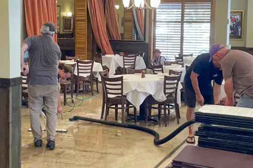 Workers dry the floor of The Steak Knife, aNew Orleans Lakeview area restaurant, after flooding from Hurricane Francine Thursday, Sept. 12, 2024. (AP Photo/Brett Martel)
