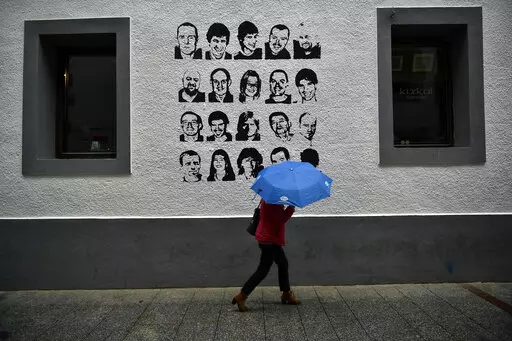 A woman shelters from the rain under an umbrella, while walking past a wall painted with portraits of prisoners of the Basque separatist armed group ETA, in the small village of Hernani, northern Spain, May 2, 2018. The United States is poised to remove five extremist groups, all believed to be defunct, from its list of foreign terrorist organizations. Several of these groups once posed significant threats, killing hundreds if not thousands of people across Asia, Europe and the Middle East. The 