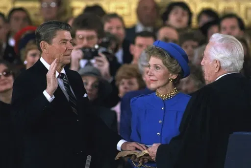 First lady Nancy Reagan, center, looks on as President Ronald Reagan is sworn in during ceremonies in the Rotunda beneath the Capitol Dome in Washington, Jan. 21, 1985. (AP Photo/Ron Edmonds, File)