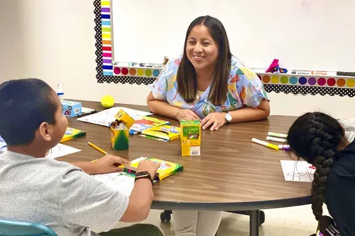 Lety Vargas, a newly hired English Language teacher at Russellville Elementary School, in Russellville, Ala., coaches small groups of students on her first day of school, Aug. 9, 2022. For years, rural Russellville's Central American population has grown, with immigrants moving to town to work at the local chicken processing plant. Now, some Spanish-speaking adults who graduated from that same school system are returning to teach students, hoping to give today's English learners a better experie