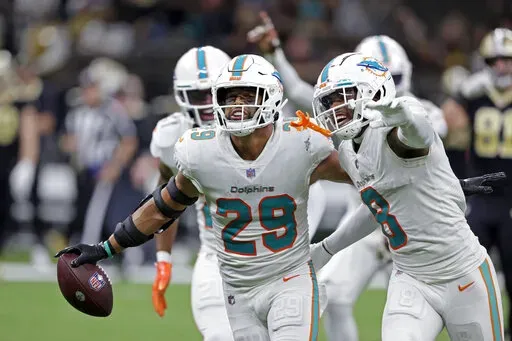Miami Dolphins safety Brandon Jones (29) celebrates with Jevon Holland (8) after intercepting a pass against the New Orleans Saints during the second half of an NFL football game Monday, Dec. 27, 2021, in New Orleans. The Dolphins won 20-3. (AP Photo/Butch Dill)