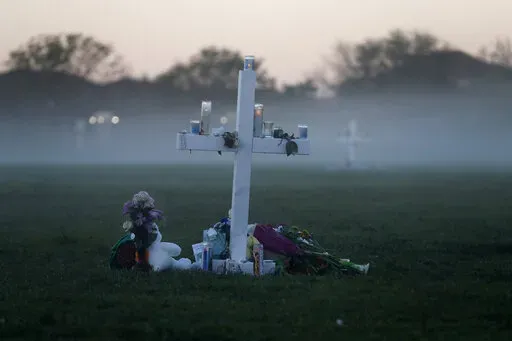 In this Feb. 17, 2018, file photo, an early morning fog rises where 17 memorial crosses were placed for the 17 students and faculty killed in the shooting at Marjory Stoneman Douglas High School in Parkland, Fla. The 12 jurors and 10 alternates chosen this past week to decide whether Cruz is executed will be exposed to horrific images and emotional testimony, but must deal with any mental anguish alone. (AP Photo/Gerald Herbert, File)