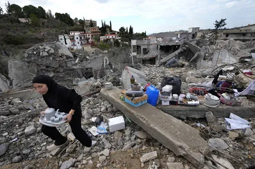 A woman collects the remains of her destroyed house after she returned to Chehabiyeh village, southern Lebanon, Thursday, Nov. 28, 2024 following a ceasefire between Israel and Hezbollah that went into effect on Wednesday.(AP Photo/Hussein Malla)