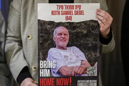 Tal Wax poses in Madrid on Thursday, Jan. 25, 2024, with a poster showing her uncle Keith Siegel, an Israeli-American hostage held in Gaza since the Oct. 7 attacks by Hamas. (AP Photo/Manu Fernandez, File)