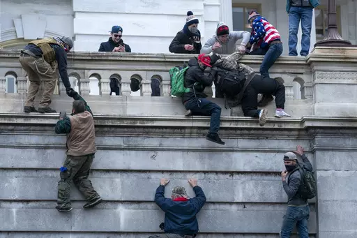 Rioters loyal to President Donald Trump climb the west wall of the the U.S. Capitol, Jan. 6, 2021, in Washington. (AP Photo/Jose Luis Magana, File)
