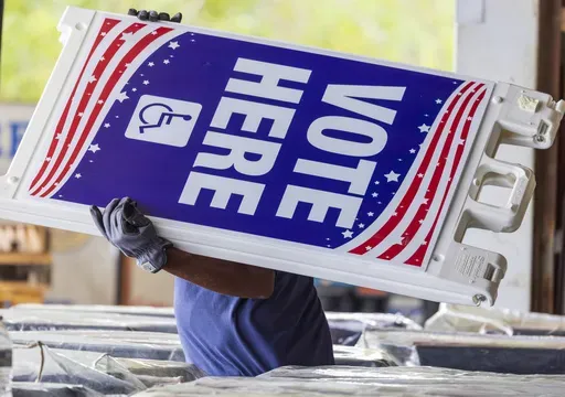 Voting machines and signs are loaded onto trucks from a warehouse in New Orleans East for delivery across the parish on Monday, Nov. 4, 2024, the day before the presidential election. (Chris Granger/The Times-Picayune/The New Orleans Advocate via AP)