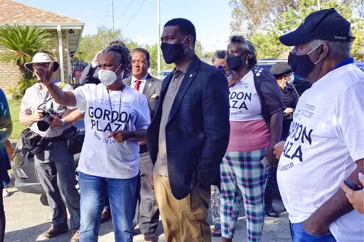 EPA Administrator Michael Regan, center, listens as resident Shannon Rainey speaks during tour of Gordon Plaza neighborhood in New Orleans, on Nov. 17, 2021. A group of New Orleans residents whose homes were built on a toxic landfill decades ago have won a $75.3 million court judgement against the city, its housing authority and the local school board. The ruling says the housing authority and the parish school board were liable for building two residential communities — Gordon Plaza and Press