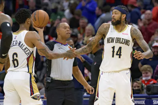 New Orleans Pelicans forward Brandon Ingram (14) and guard Nickeil Alexander-Walker (6) celebrate late in the team's win over the Portland Trail Blazers in an NBA basketball game in New Orleans, Tuesday, Dec. 21, 2021. (AP Photo/Matthew Hinton)